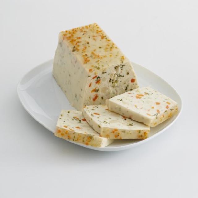 sur un plat en faïence blanche, une terrine rectangulaire de saumon et de saint-jacques, avec sur le devant trois tranches coupées et posées en éventail