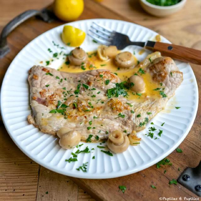 une escalope de poulet nappée de sauce aux herbes