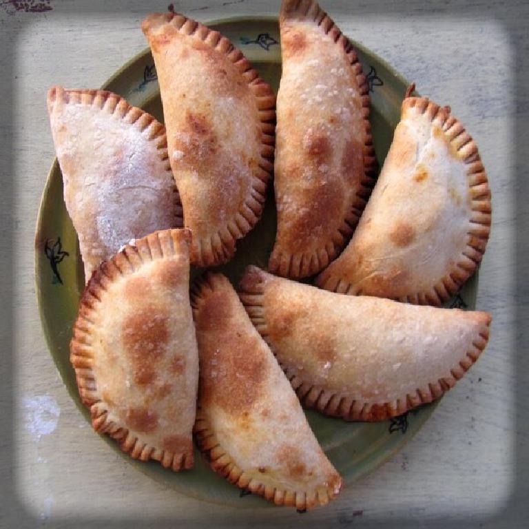 sur une assiette en faïence, 7 cocas niçois (petits chaussons de pâte fourrés à la ratatouille)