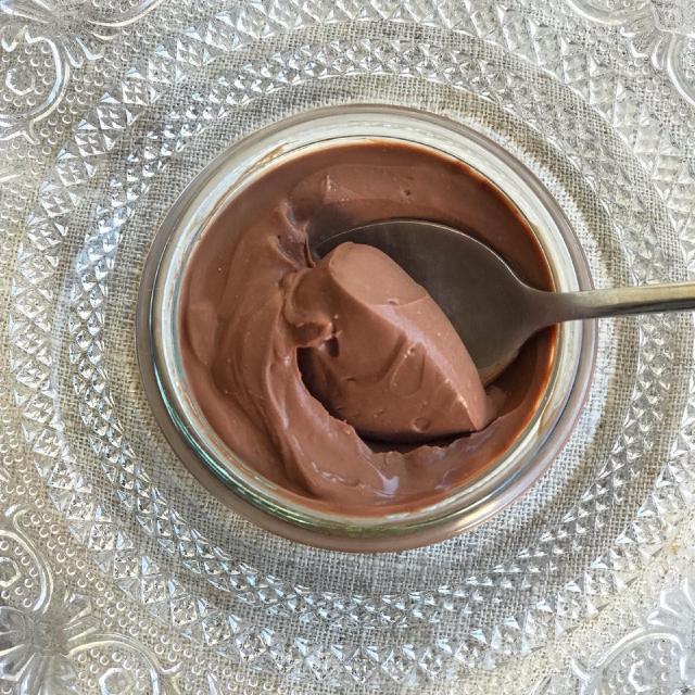 un pot de crème au chocolat sur un napperon brodé