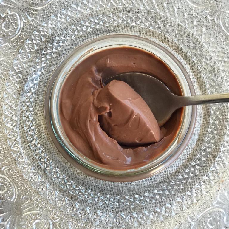 un pot de crème au chocolat sur un napperon brodé