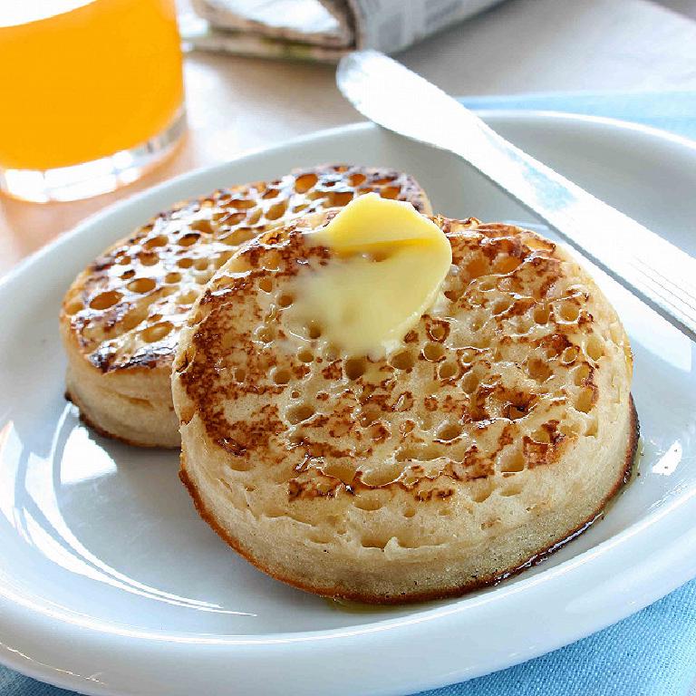 Une assiette avec deux crumpets, petis pains anglais avec des trous