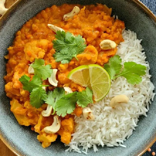 un plat de lentilles corail en sauce avec du riz d'accompagnement
