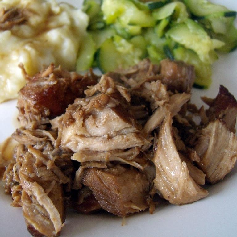 une assiette avec de la viande de porc confite, accompaghnée de courgette et pommes de terre