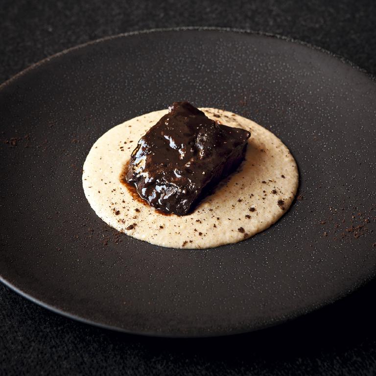 une galette de polenta avec un morceau de daube de boeuf posé dessus