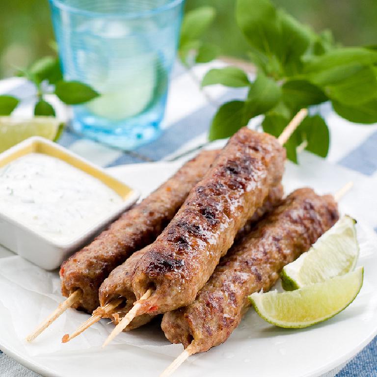 une assiette avec des brochettes de viande kefta cuites au barecue