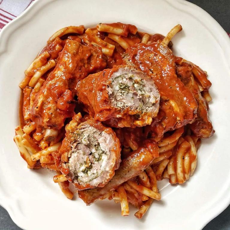 une assiette blanche remplie de pâtes type penne et par dessus des encornets farcis et une sauce rouille
