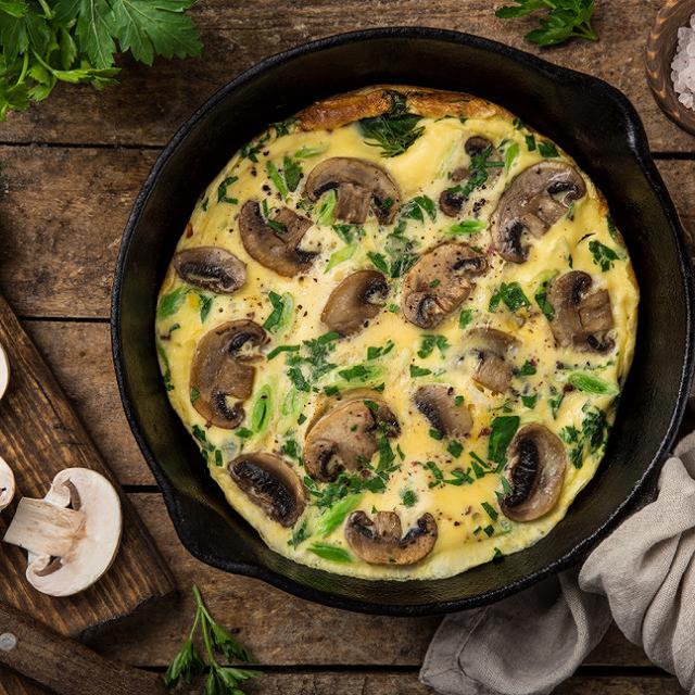 une pôele avec une omelette aux champignons