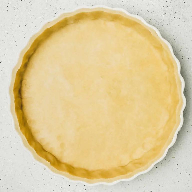 un moule à pâtisserie avec un fond de pâte brisée non cuite