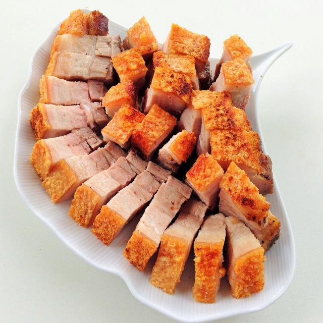 des morceaux de porc laqué croustillant dans une assiette blanche