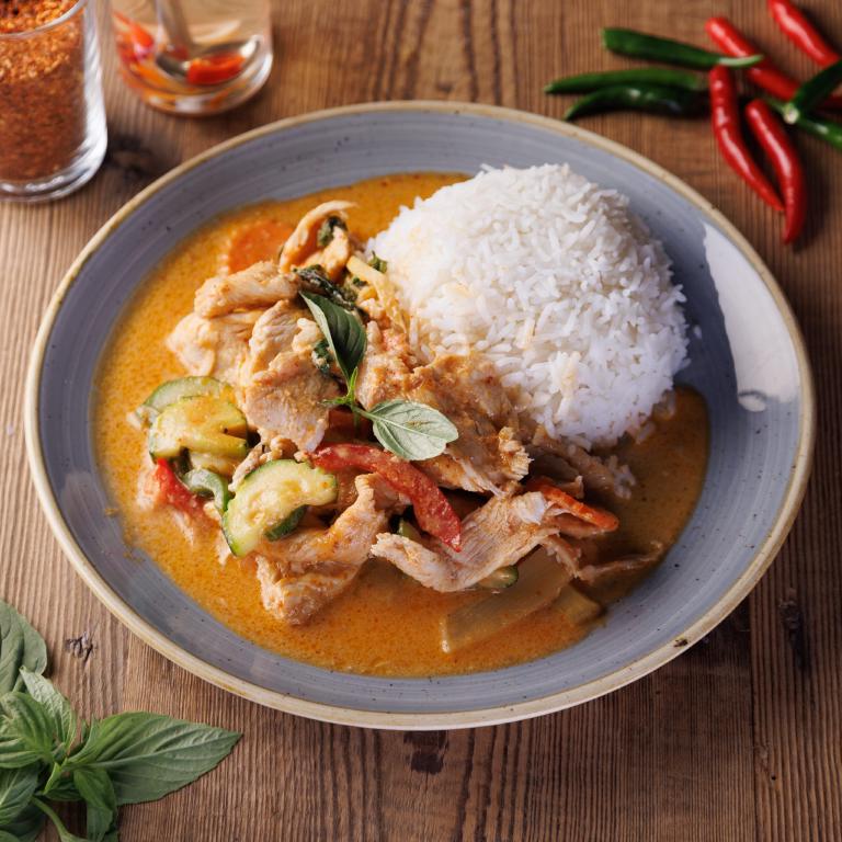 une assiette de poulet thaî avec sa sauce et du riz blanc