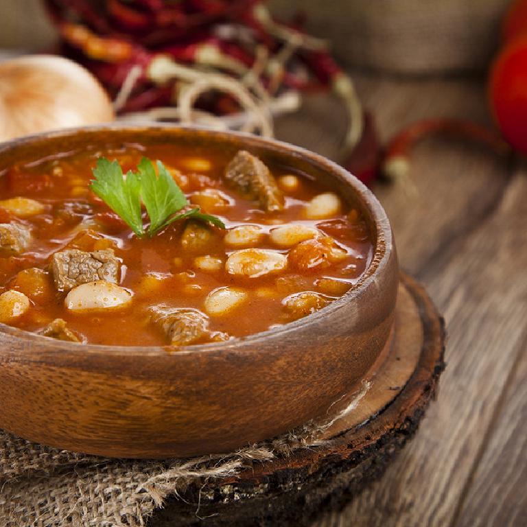 Un plat en terre cuite rempli de ragoût d'agneau avec des haricots blancs