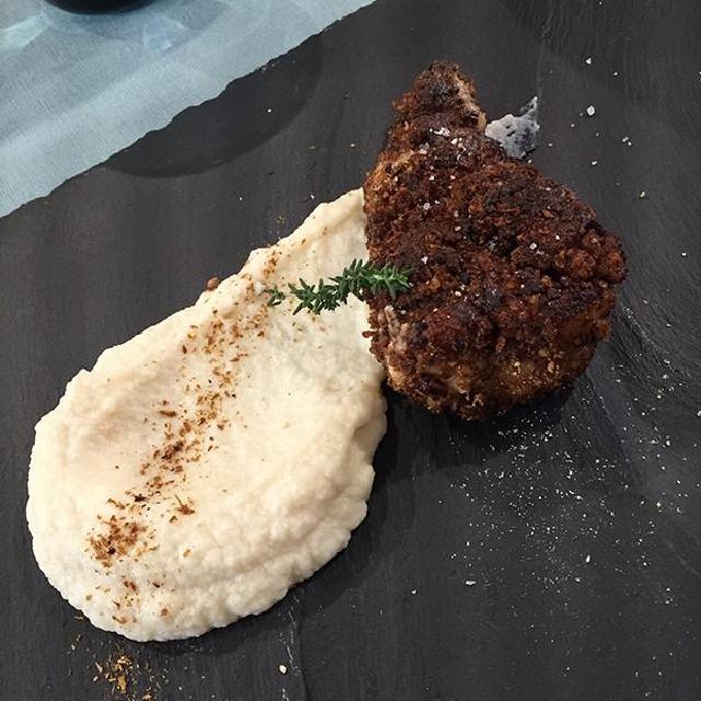 une assiette avec un ris de veau pané et de la purée de chou-fleur