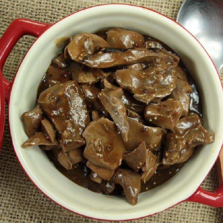 dans une cassolette en émail rouge, des morceaux de rognons de veau nappés d'une sauce d'un beau brun foncé