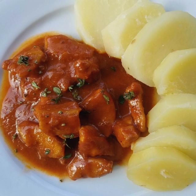 une assiette avec des seiches à la sétoise, la sauce rouille et des pommes de terre
