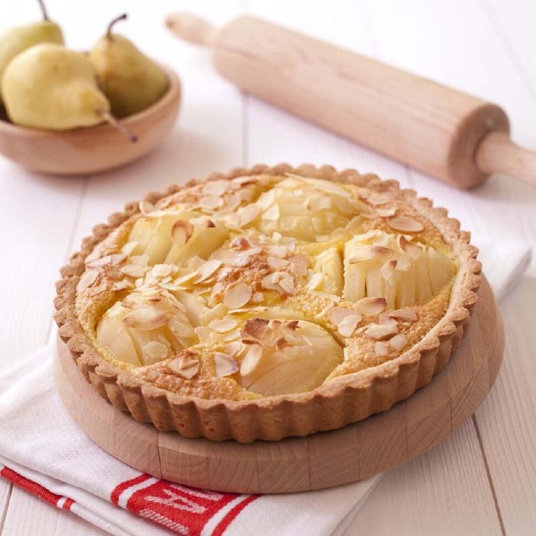 une tarte bourdaloue sur un plat en bois, tarte à base de poire et de crème d'amande