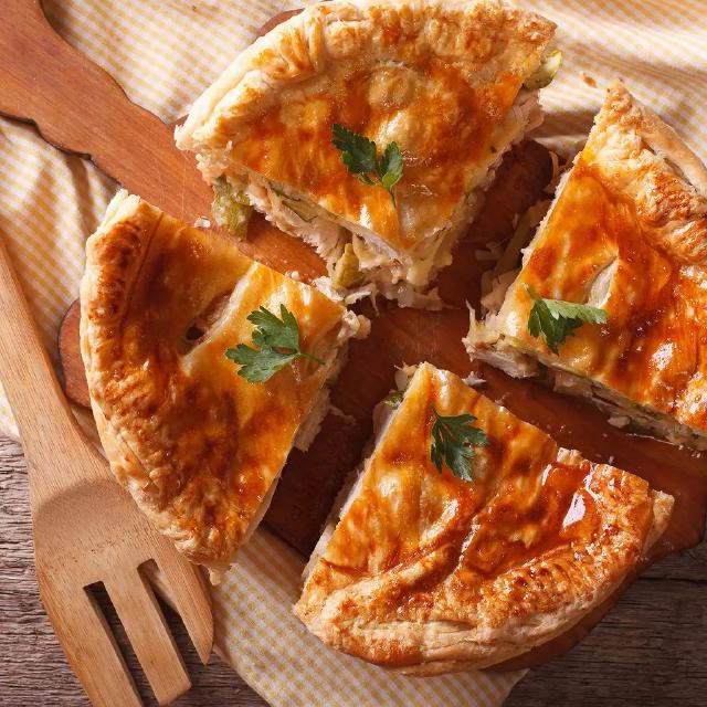 une tourte au poulet et aux champigonns coupée en quatre parts