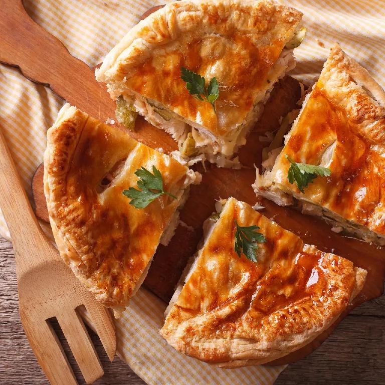 une tourte au poulet et aux champigonns coupée en quatre parts
