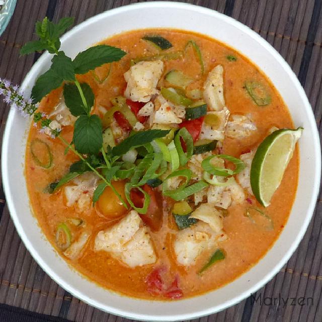 un bol de poisson dans une sauce au curry rouge